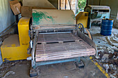 The first wool cleaning machine at Hilandería Warmi, a weaving mill in Palpalá, Argentina. Rollers in the machine crush chunks of debris stuck in the wool