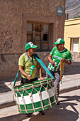 A drummer and siku panpiper prepares for a religious procession in front of the church in Tilcara, Argentina.