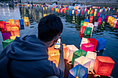 People float lanterns on the river, in front of Atomic Bomb Dome with floating lamps on Motoyasu-gawa River during Peace Memorial Ceremony every August 6 in Hiroshima, Japan