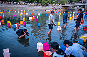 Press at work, in front of Atomic Bomb Dome with floating lamps on Motoyasu-gawa River during Peace Memorial Ceremony every August 6 in Hiroshima, Japan