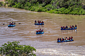 Tourists enjoy a rafting trip on a flat-water stretch of the Colorado River near Moab, Utah.