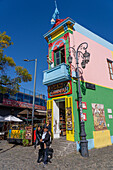 A tourist poses for a photo with a tango dancer on Caminito in La Boca, Buenos Aires, Argentina.