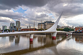 La Puente de la Mujer or the Woman's Bridge over Dock 3 in Puerto Madero, Buenos Aires, Argentina. Behind is the Libertador Building, headquarters of the Ministry of Defense.