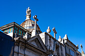 Crosses & a statue on elaborate tombs or mausoleums in the Recoleta Cemetery, Buenos Aires, Argentina.