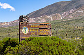 Schild am Westeingang des Nationalparks Los Cardones mit dem Cerro Tin Tin dahinter in der Provinz Salta, Argentinien