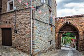 Der alte Torbogen Puerta del Rio steht stolz in Yanguas und versprüht vor dem Hintergrund eines bedeckten Himmels rustikalen Charme