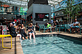 Clients refresh by the pool at Manifesto Market, a must-visit cultural experience in the heart of Prague with pop-up design retail experience bars and high-quality street food.