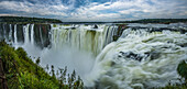 The water of the Iguazu River falls over the precipice of the Garganta del Diablo or the Devil's Throat Waterfall in Iguazu Falls National Park in both Argentina and Brazil. Both parks are UNESCO World Heritage Sites. At left is Brazil, at right is Argentina.