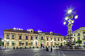 The beautifully lit Palacio Arzobispal stands majestically against the evening sky in Seville, showcasing its architectural elegance.