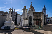 Elaborate tombs in the Recoleta Cemetery, Buenos Aires, Argentina. Behind is the Basilica de Nuestra Senora del Pilar.