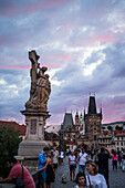 View of city skyline at sunset from Charles Bridge in Prague