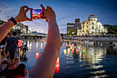 People float lanterns on the river, in front of Atomic Bomb Dome with floating lamps on Motoyasu-gawa River during Peace Memorial Ceremony every August 6 in Hiroshima, Japan