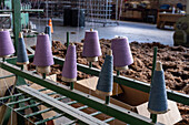 Spools of different colors for making variegated yarn for weaving at Hilandería Warmi, a weaving mill in Palpalá, Argentina.