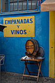 Sign and table with a wooden cask by the entrance to a small cafe in Caminito, La Boca, Buenos Aires, Argentina.