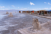 Statues carved from salt & vendors stalls made of salt blocks at the Salinas Grandes salt flats on the altiplano in Argentina.