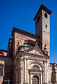 The striking Torre del Gallo and Puerta del Mercado showcase the rich history of Sigüenza Cathedral in Guadalajara, Spain, under a bright blue sky.