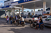 Motorcyclists and cars wait in line for fuel at a service station in Monteros, Tucumán Province, Argentina.