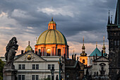 View of St. Francis of Assisi Church and city skyline at sunset from Charles Bridge in Prague