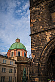 View of St. Francis of Assisi Church and city skyline at sunset from Charles Bridge in Prague