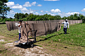 Workers hanging washed textiles outside on lines to dry at Hilandería Warmi, a weaving mill in Palpalá, Argentina.