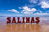 A metal sign on the Salinas Grandes salt flats on the altiplano in Argentina. Recent rains left a shallow sheet of water on the flats.