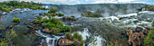 A panoramic image of the Iguazu River flowing over the precipice of the San Martin Waterfall in Iguazu Falls National Park in Argentina. A UNESCO World Heritage Site.