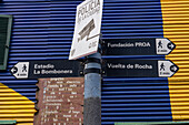 Street sign with a colorfully-painted building on Dr. del Valle Iberlucea Street in Caminito, La Boca, Buenos Aires, Argentina.