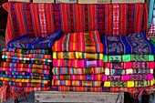 Colorful Andean weavings with Inca or Aymara designs for sale in an open market on the square in Tilcara, Argentina.