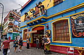 A caricature statue of a musician playing a bandoneon or concertina in front of a shop in Caminito, La Boca, Buenos Aires, Argentina.