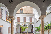 Seville, Spain, Nov 15 2009, Explore the serene inner courtyard of the 16th-century Santa Isabel convent in Seville, featuring elegant arches and lush greenery.