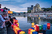 People float lanterns on the river, in front of Atomic Bomb Dome with floating lamps on Motoyasu-gawa River during Peace Memorial Ceremony every August 6 in Hiroshima, Japan