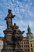 Statue des Heiligen Ivo von Kermartin und alter Turm an der Karlsbrücke in Prag