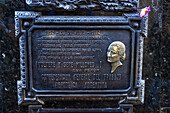 Bronze plaque on the mausoleum of Eva "Evita" Peron in the Recoleta Cemetery, Buenos Aires, Argentina. A flower was left by a visitor.