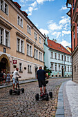 Tourists in Prague Castle complex with four wheeled scooters