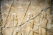 Berlin, Germany, July 24 2009, Explore the intricate Assyrian relief featuring ancient warriors at the Pergamon Museum in Berlin, showcasing a rich historical narrative.