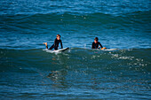 Surfers in Grande Plage beach of Biarritz, France