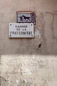 A street sign marking Carrer de la Fraternitat, showcasing local culture in the Gracia neighborhood of Barcelona.