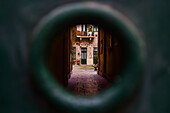 View of house patio from hole on door, Budapest