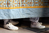 Participants can be seen wearing white shoes while carrying a float during the Corpus Christi procession in Seville, Spain.