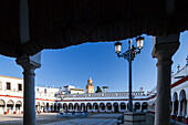 The vibrant market in Carmona features stunning whitewashed walls and a peaceful atmosphere, inviting visitors to explore and shop.