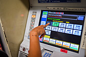 Hand of woman using train and subway ticket machine, Kyoto, Japan