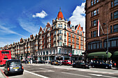 London, UK, May 2 2009, Busy street in London showcases the stunning architecture of 79 Brompton Road, filled with classic cars and pedestrians enjoying the day.