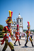 Parade passing by São João Baptista Church during The Festival of Saint John of Sobrado, also known as Bugiada and Mouriscada de Sobrado, takes place in the form of a fight between Moors and Christians , locally known as Mourisqueiros and Bugios, Sao Joao de Sobrado, Portugal