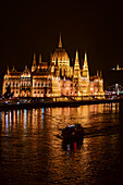 Illuminated Parliament building and Danube River it night, Budapest, Hungary, Europe