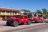 Off-road Hummer from a tour company towing a raft in the Fourth of July Parade on Independence Day in Moab, Utah.