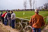 People watching a soccer youth game in small town of Hungary