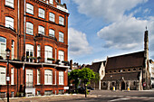 A beautiful Victorian house stands next to a charming church on Lennox Gardens in Kensington, capturing the essence of London.