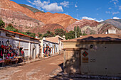 Tourist shops on Calle Florida in Purmamarca, Argentina, with the Hill of Seven Colors behind.