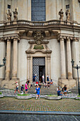 People in the entrance stairs of Church of St. Nicholas, Prague