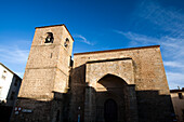 Explore the architectural beauty of Iglesia de San Nicolás in Plasencia, Cáceres, illuminated by the warm hues of sunset.